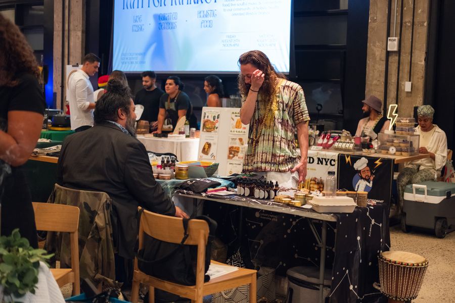 A vendor setting out plant-based products and preserves at a summer Mindful Matter Market in New York