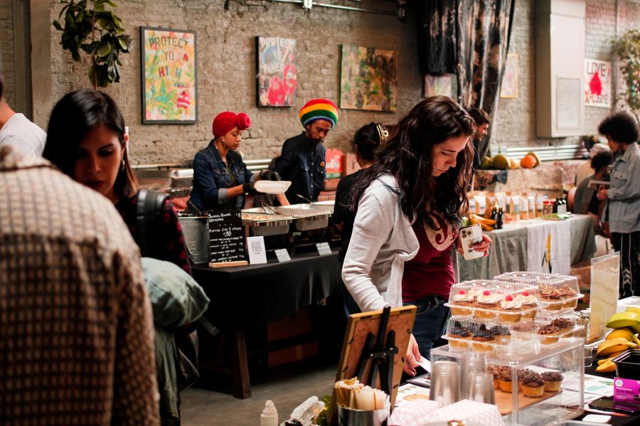 A guest choosing vegan baked goods from a vendor display at a Mindful Matter Market